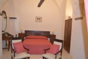 a bedroom with a red bed and two chairs at Domus Lina in Ravello