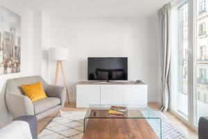 salon z kanapą i telewizorem w obiekcie Charming 1-Bedroom Apartment in Central Madrid Stylish Retreat for 2, Alonso Martinez I w Madrycie
