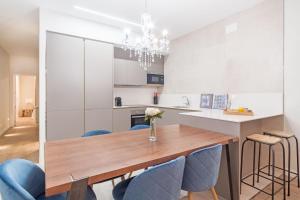 eine Küche mit einem Holztisch und blauen Stühlen in der Unterkunft Experience the best of Madrid! Gran Vía Apartment for 6, comfort and style in the heart of Chueca III in Madrid