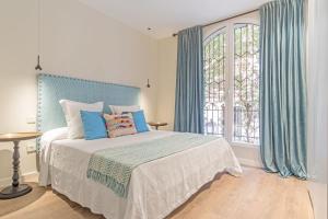 Schlafzimmer mit einem großen Bett und blauen Vorhängen in der Unterkunft Experience the best of Madrid! Gran Vía Apartment for 6, comfort and style in the heart of Chueca III in Madrid