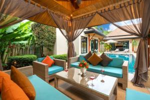 un patio al aire libre con muebles y una piscina en Luxury Tropical Garden Pool Villa, en Rawai Beach