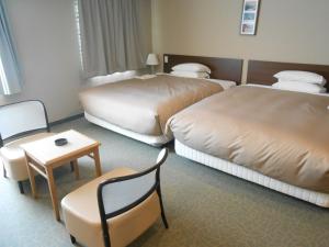 A bed or beds in a room at Hotel Crown Hills Sendai Aobadori