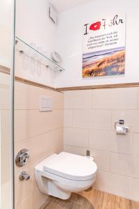 a bathroom with a toilet and a shower at Haus Uthlande HAus Uthlande Whg 46 Watten Blick in Wyk auf Föhr