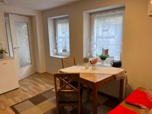 a dining room with a table and two windows at Ferienwohnung Heyne in Weinböhla +11 photos