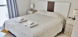a bedroom with a bed with two towels on it at Departamento Céntrico in Puerto Madryn