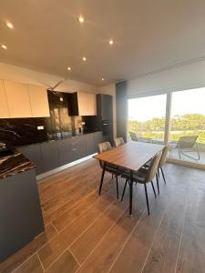 a kitchen and dining room with a wooden table and chairs at One Bedroom in New Apt Mellieha- Blue Room 2 in Mellieħa