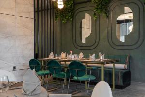 Un comedor con una mesa y sillas verdes. en Best Western Plus Trabzon, en Trabzon
