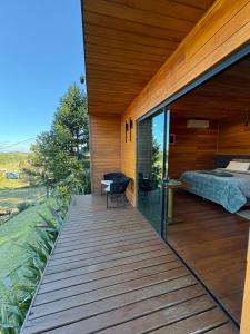 a wooden deck with a bedroom and a bed on it at Refúgio de Altitude in Urupema
