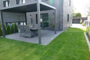 a patio with a table and chairs in a yard at Ferienhaus am Lankower See in Schwerin