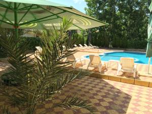 una sombrilla y sillas verdes y una piscina en Beatris Family House, en Sunny Beach