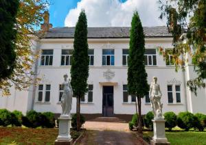 a white house with statues in front of it at Apple Manor & Garden Complex  +32 photos