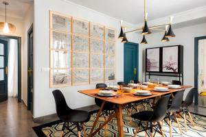 a dining room with a wooden table and chairs at Genteel Home Albareda in Seville