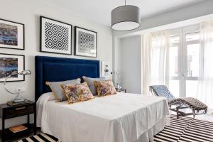 a bedroom with a bed with a blue headboard at Genteel Home Albareda in Seville