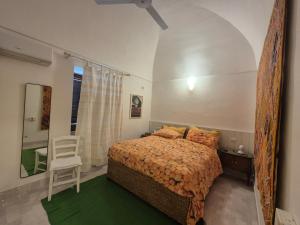 a bedroom with a bed and a chair and a mirror at Dammusi A-mare in Pantelleria