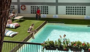 a group of people playing in a swimming pool at Plus Florence in Florence