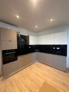 a kitchen with white cabinets and a wooden floor at One Bedroom in New Apt Mellieha- Blue Room 2 in Mellieħa +3 photos