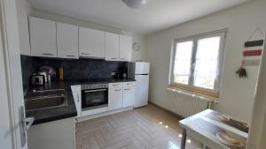 une cuisine avec des appareils électroménagers blancs et une fenêtre dans l'établissement Ferienhaus Barbey, à St. Blasien 12 autres photos