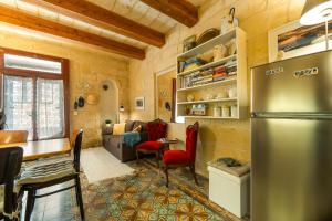 a kitchen and living room with a stainless steel refrigerator at Cosy Haven, 96 Triq il-Karita', Victoria Gozo in Victoria