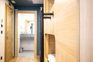 bagno con porta in legno e lavandino di Pensión da Sela a Santiago de Compostela