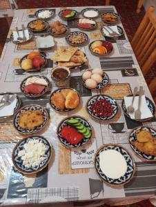 a table topped with lots of different types of food at Fayz Guest House in Khiva