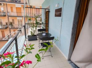 a balcony with a table and chairs and flowers at B&B SediciMarzo in Scalea
