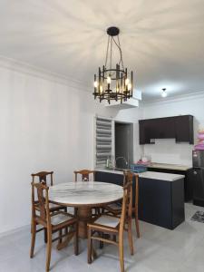 a kitchen with a table and chairs and a chandelier at Angsana Raintree Batu Caves with balcony 3Bedroom 2Bathroom in Batu Caves