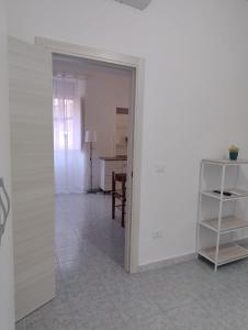 Habitación con pared blanca y mesa. en La Casa Di Nonna Lucrezia, en Orsomarso