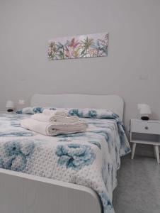 Una cama con una manta azul y blanca encima. en La Casa Di Nonna Lucrezia, en Orsomarso