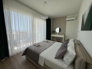 a bedroom with a large bed and a large window at Privat Pool Green Gem Villa 82, Green Coast in Dhërmi +33 photos