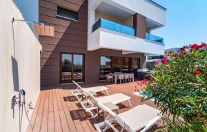 a patio with white chairs and tables on a house at Villa Estate in Novalja
