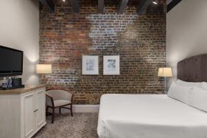 a bedroom with a bed and a brick wall at Dauphine Orleans Hotel in New Orleans +24 photos