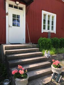 a red house with a white door and some flowers at Lillby Bed and breakfast2 in Lehtinen