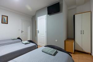a room with two beds and a flat screen tv at Villa Miranda NG in Ohrid