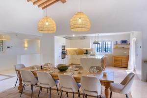 a kitchen and dining room with a wooden table and chairs at Lovely luxury villa with garden and private pool in Sainte-Maxime