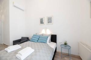 a bedroom with a bed with blue and white pillows at Modern studio with AirCon and balcony in the center in Budapest