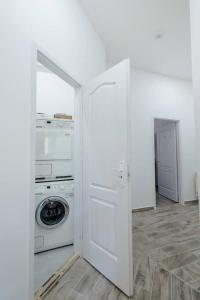 a white laundry room with a washer and dryer at Modern studio with AirCon and balcony in the center in Budapest +2 photos