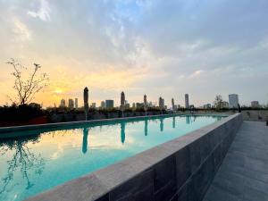 una piscina con vista sullo skyline della città sullo sfondo di HUNAB Roma Apt - Pool, Coworking and Gym NEW a Città del Messico