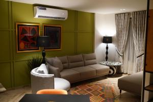 a living room with green walls and a couch at The LC Hotel in Lahore