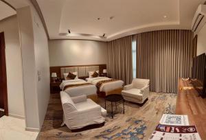 a hotel room with two beds and two chairs at فندق نوفا ليس للخدمات الفندقيه in Najran