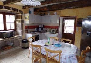 a kitchen with a table and chairs in a kitchen at La maison Chabert in Ailhon