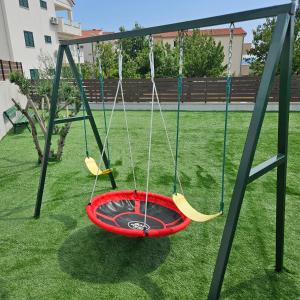 eine Schaukelanlage mit Feuerstelle im Garten in der Unterkunft SunN Joy in Kaštela