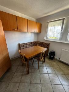 a kitchen with a wooden table and chairs and a window at PAapartment in Murg +3 photos