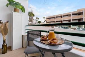 a table with a glass of orange juice and donuts on a balcony at Pippa’s House 2 in San Agustin