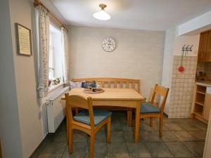 un tavolo e delle sedie in una cucina con un orologio sul muro di Ferienhof Zinn a Lauterbach