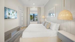 a white bedroom with a white bed and a window at Salty Sunrise in Clearwater Beach +69 photos