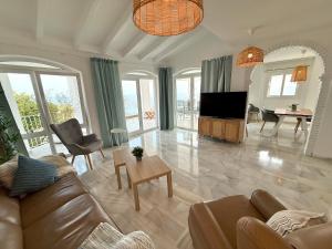 a living room with a couch and a television at Villla Clementina in Nerja