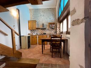 a kitchen with a table and chairs in a room at Piazzetta Del Forno - Monolocale con Soppalco in Assergi