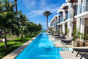 コツにあるTamala Beach Resortのヤシの木が並ぶ建物の隣のスイミングプール