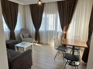 a living room with a couch and a table and chairs at Şeker Apartments in Tuzla