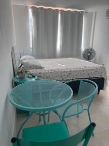 a table and chairs in a room with a bed at Loft mobiliado no centro de Guarapari in Guarapari